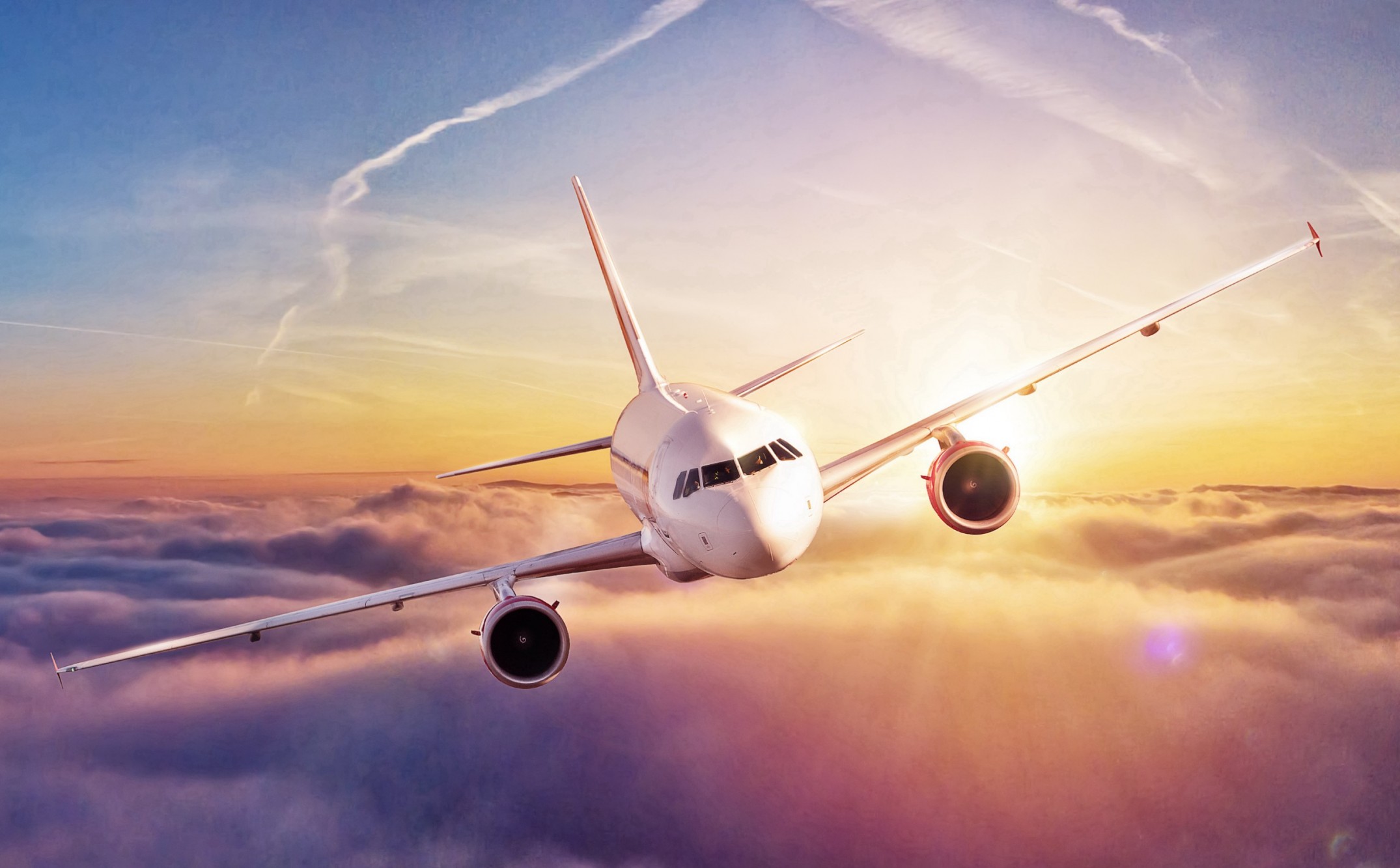 Commercial,Airplane,Flying,Above,Clouds,In,Dramatic,Sunset,Light.,High image of airplane flying above clouds in sunset light